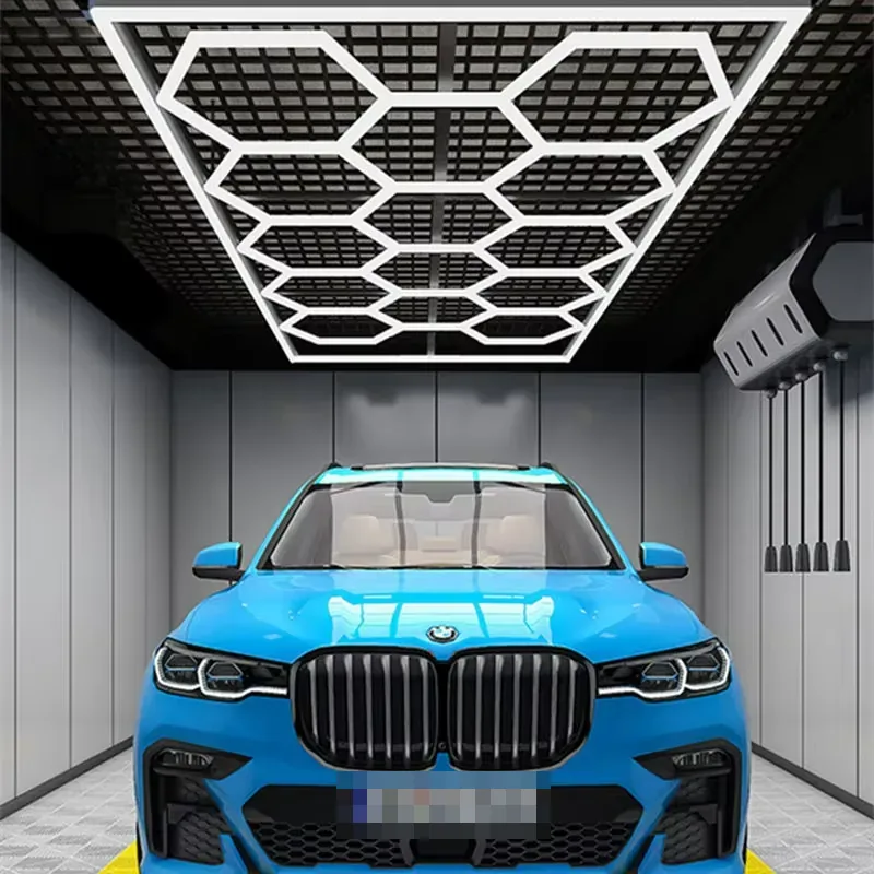 Framed honeycomb LED ceiling lighting above a blue car in an automotive bay