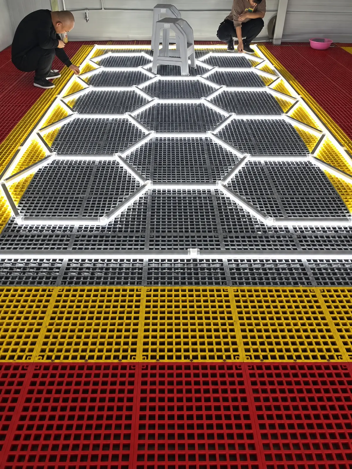 Honeycomb LED lighting illuminated during installation above a car wash floor